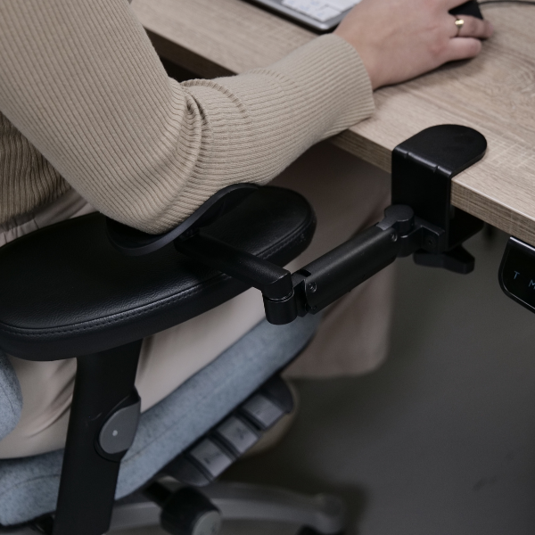 De Ergorest Medium Zwart in actie, gemonteerd op een bureau voor optimale ergonomie.